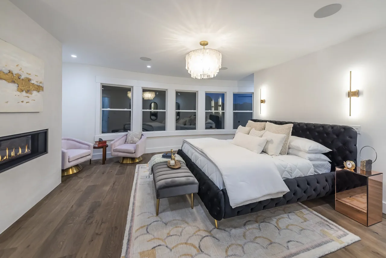 Contemporary bedroom in the Forrest Edge project with a fireplace and modern lighting fixtures.