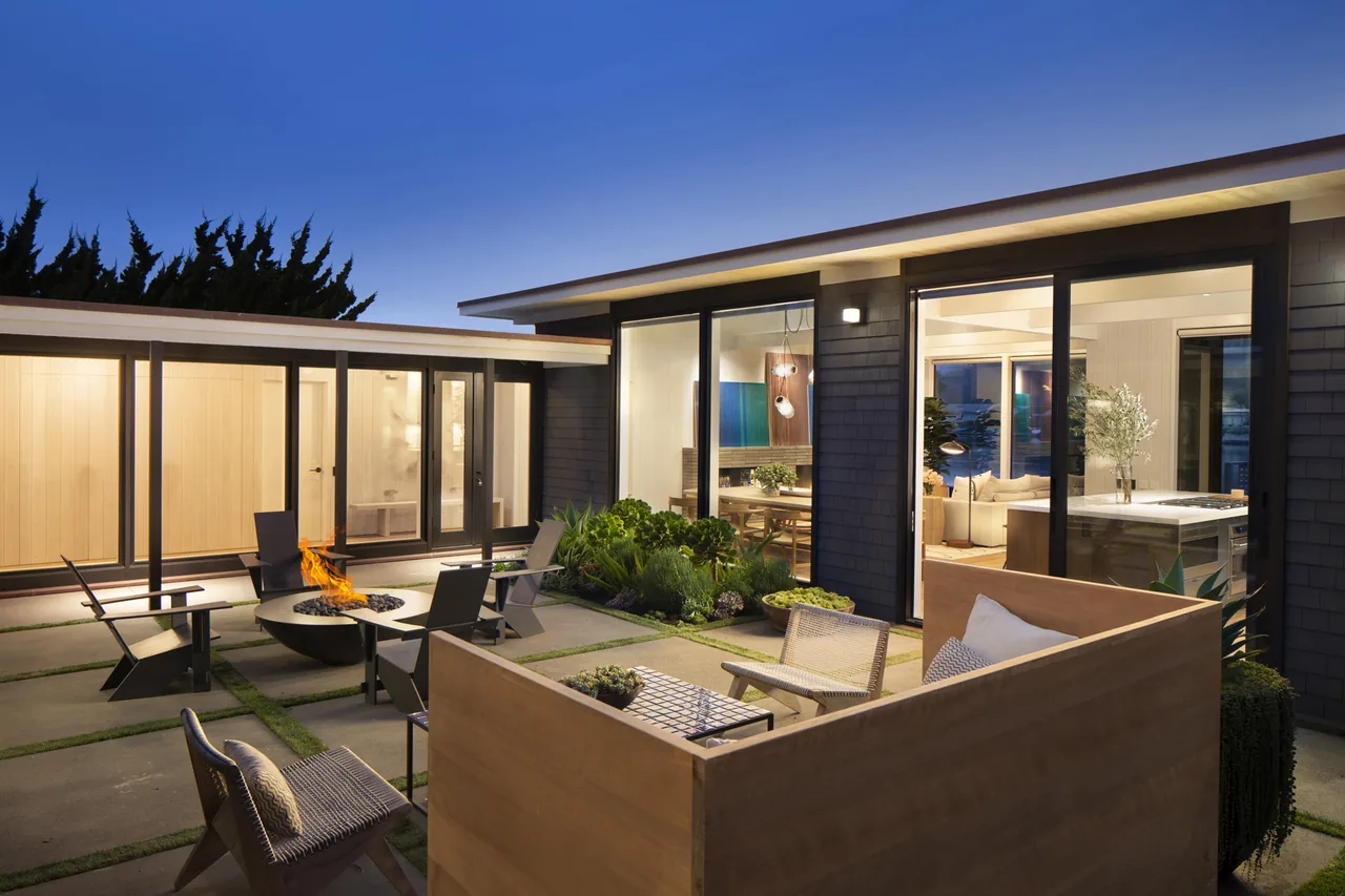 Stinson Bungalow outdoor living space with fire pit and seating, connected to interior areas by large sliding glass doors.