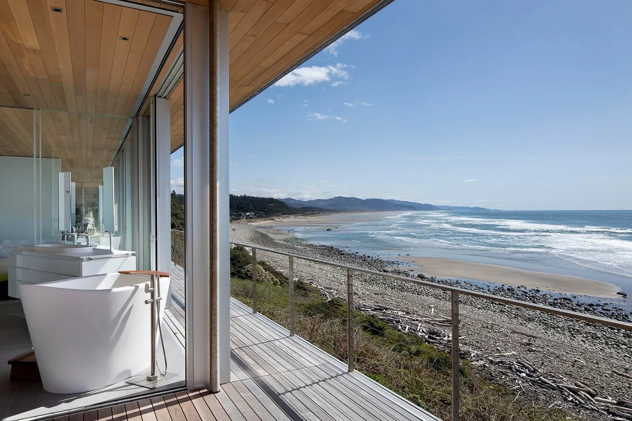 Bathroom with freestanding tub and floor-to-ceiling glazing providing ocean view from Prow House.