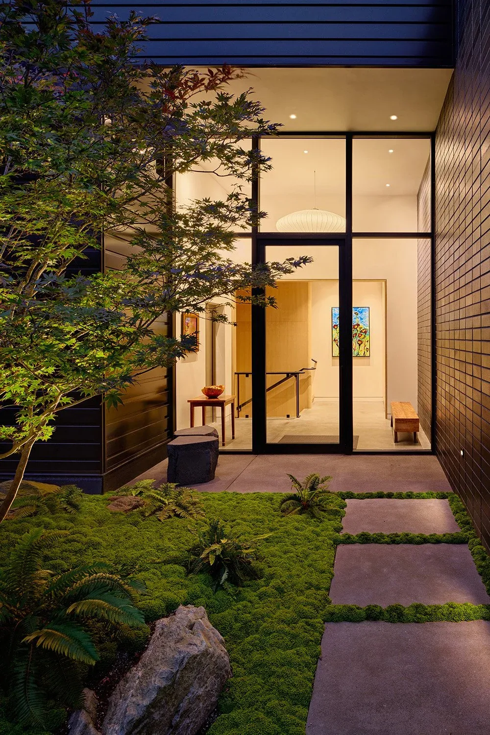 View Point Residence front entry by Chadbourne + Doss Architects features floor-to-ceiling glass and landscaped moss courtyard.