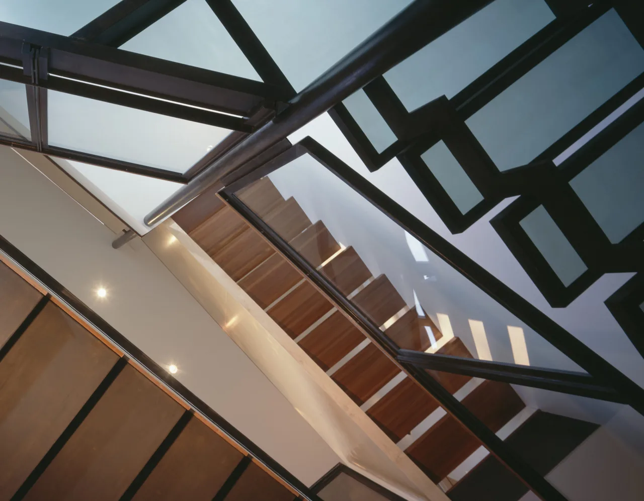Wood staircase with black metal railing and geometric design detail in Orleans House, Cape Cod.