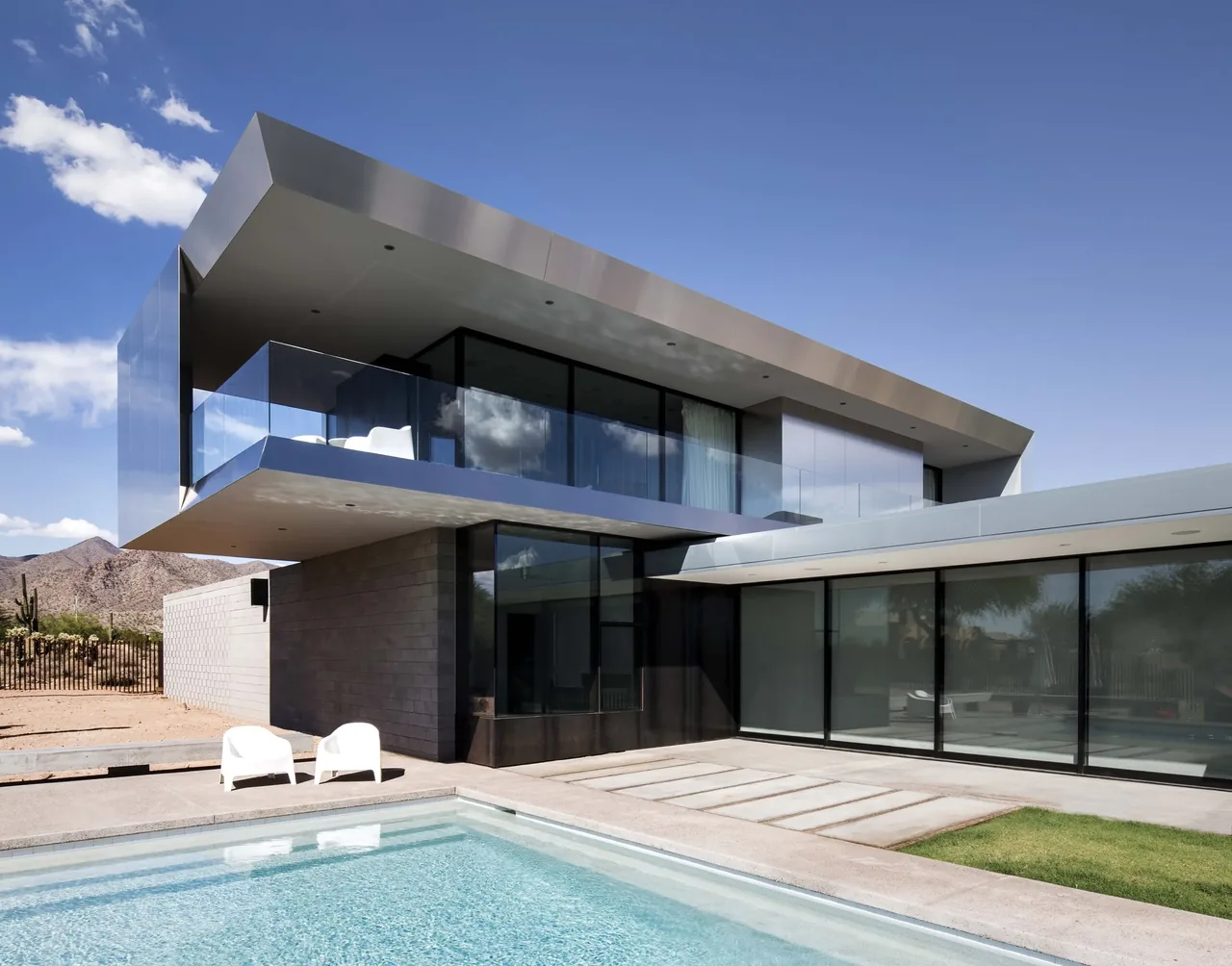 Staab residence features a distinctive cantilevered upper level with glass balcony and block wall construction by Chen Suchart Studio.