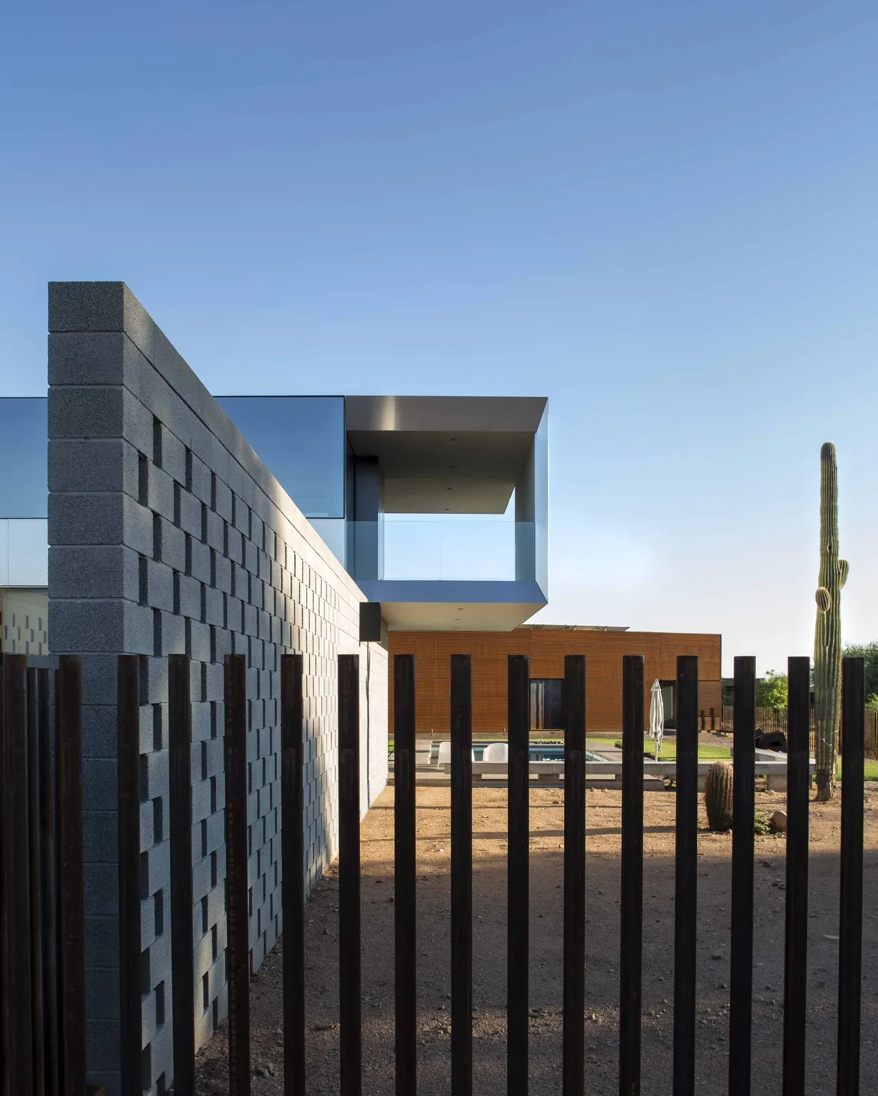 The Staab residence features a perforated concrete block wall and a cantilevered metal volume above a desert landscape setting.