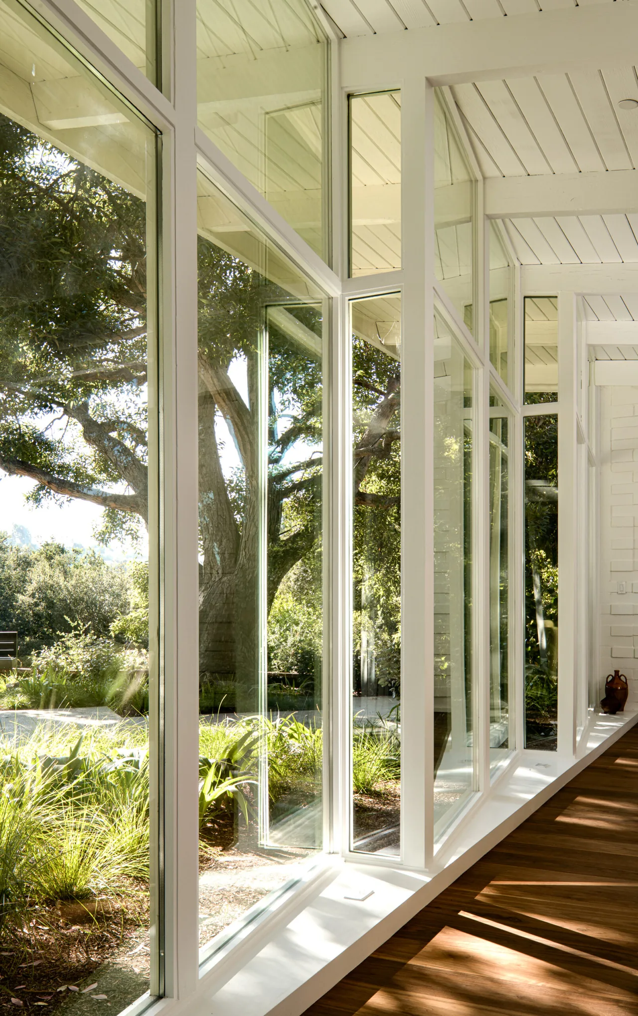 Veneklasen House features expansive floor-to-ceiling windows that open to a landscaped yard.