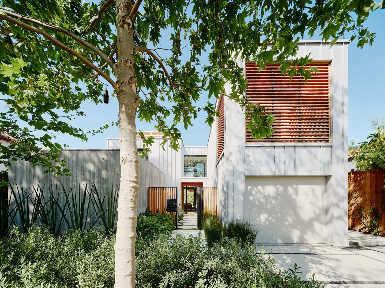 Front exterior of a modern Los Angeles residence featuring wood slat privacy screens and white panel siding.
