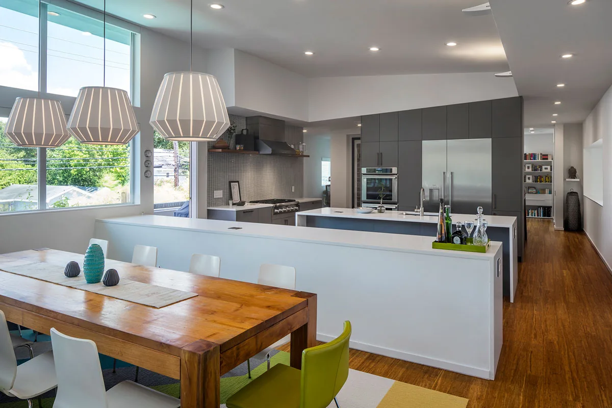 HOUSE 2344 features an open kitchen and dining space with large windows and wood flooring.