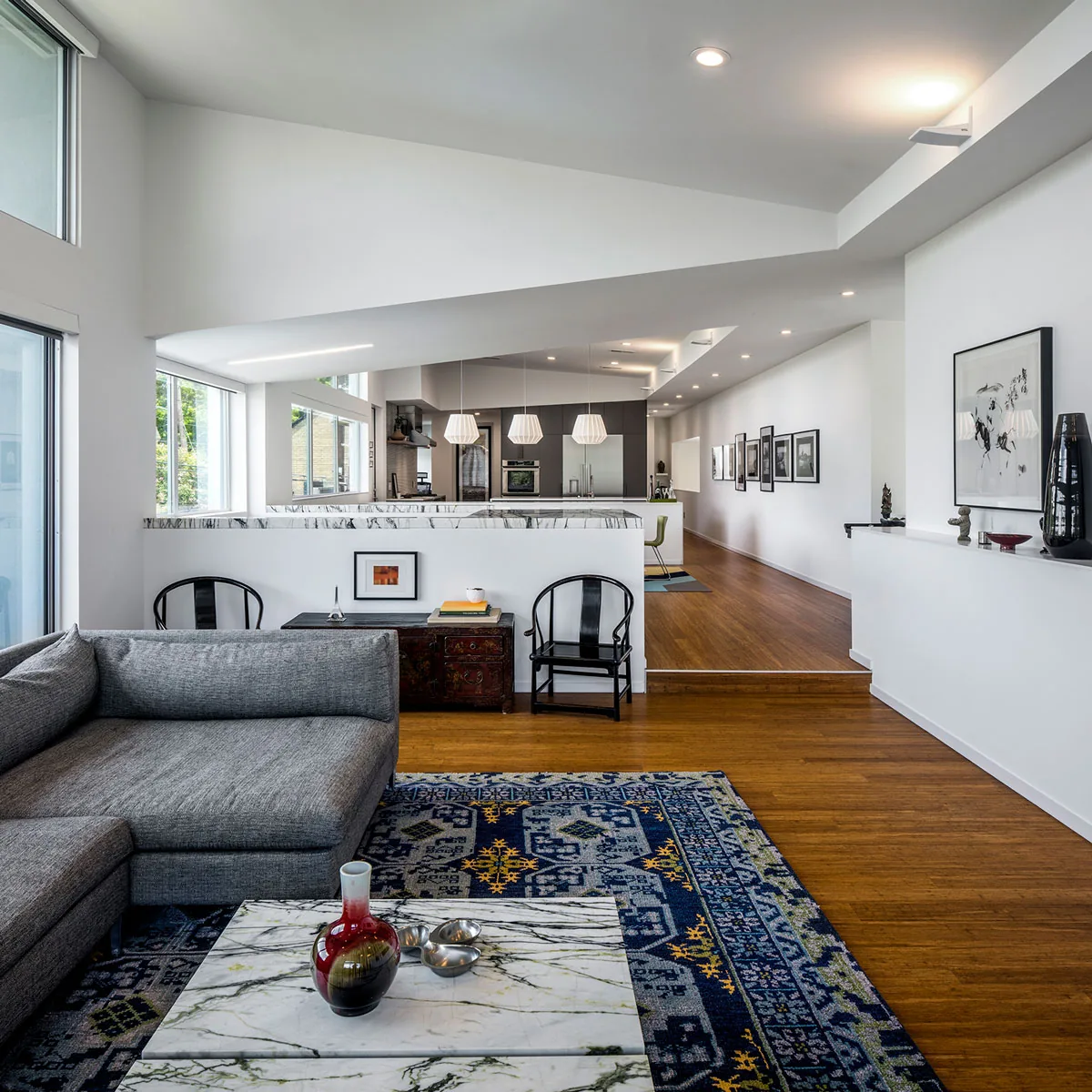 Open living area with gray sectional sofa and marble coffee table in HOUSE 2344 by Collaborative Design Works.
