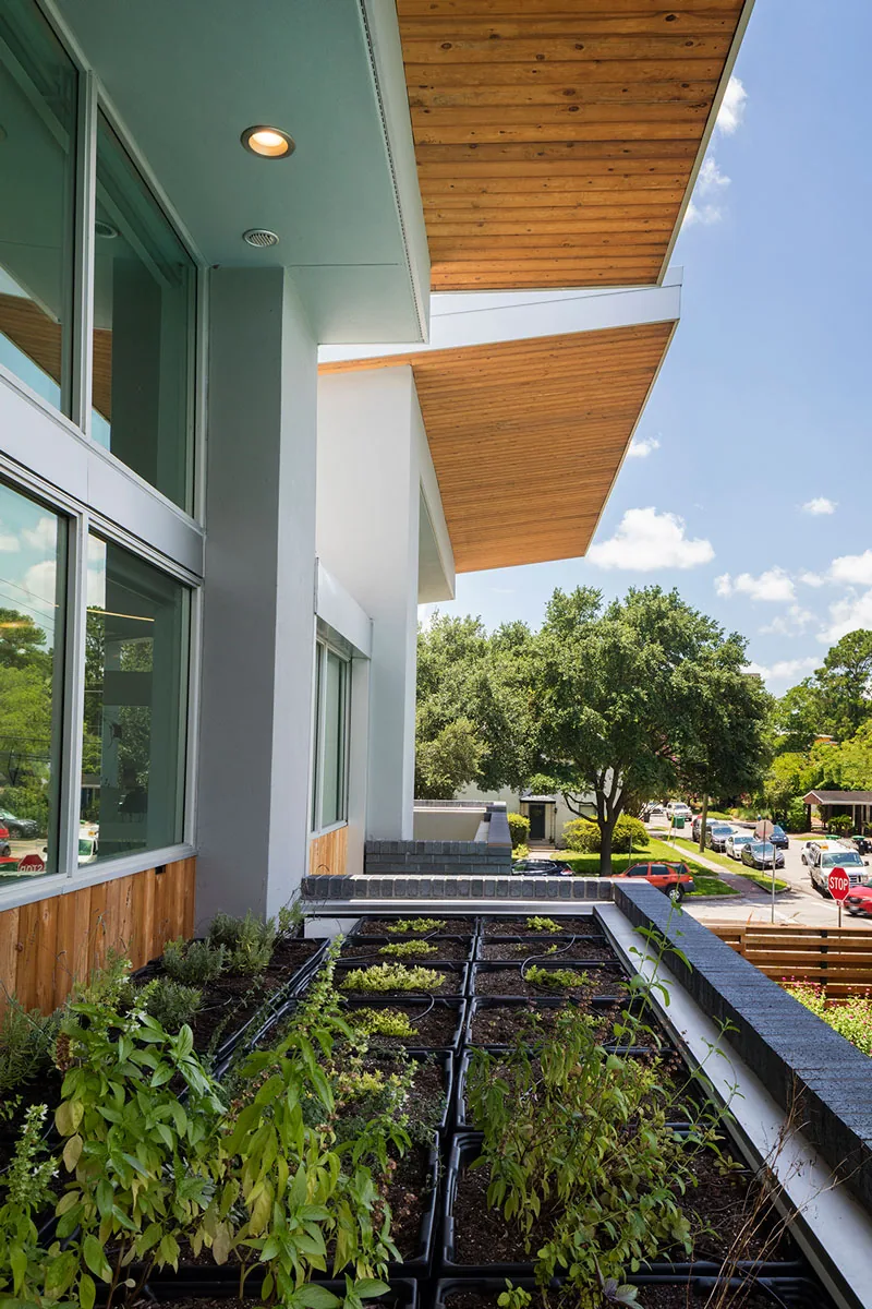 Exterior balcony with raised planter boxes and wood-paneled sloped roof of HOUSE 2344 by Collaborative Design Works.