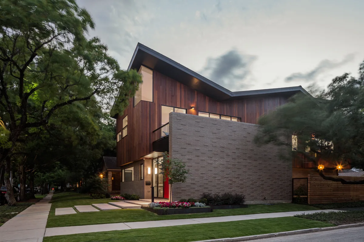 HOUSE 1700 features a modern exterior with a combination of wood siding and brickwork, designed by Collaborative Design Works.