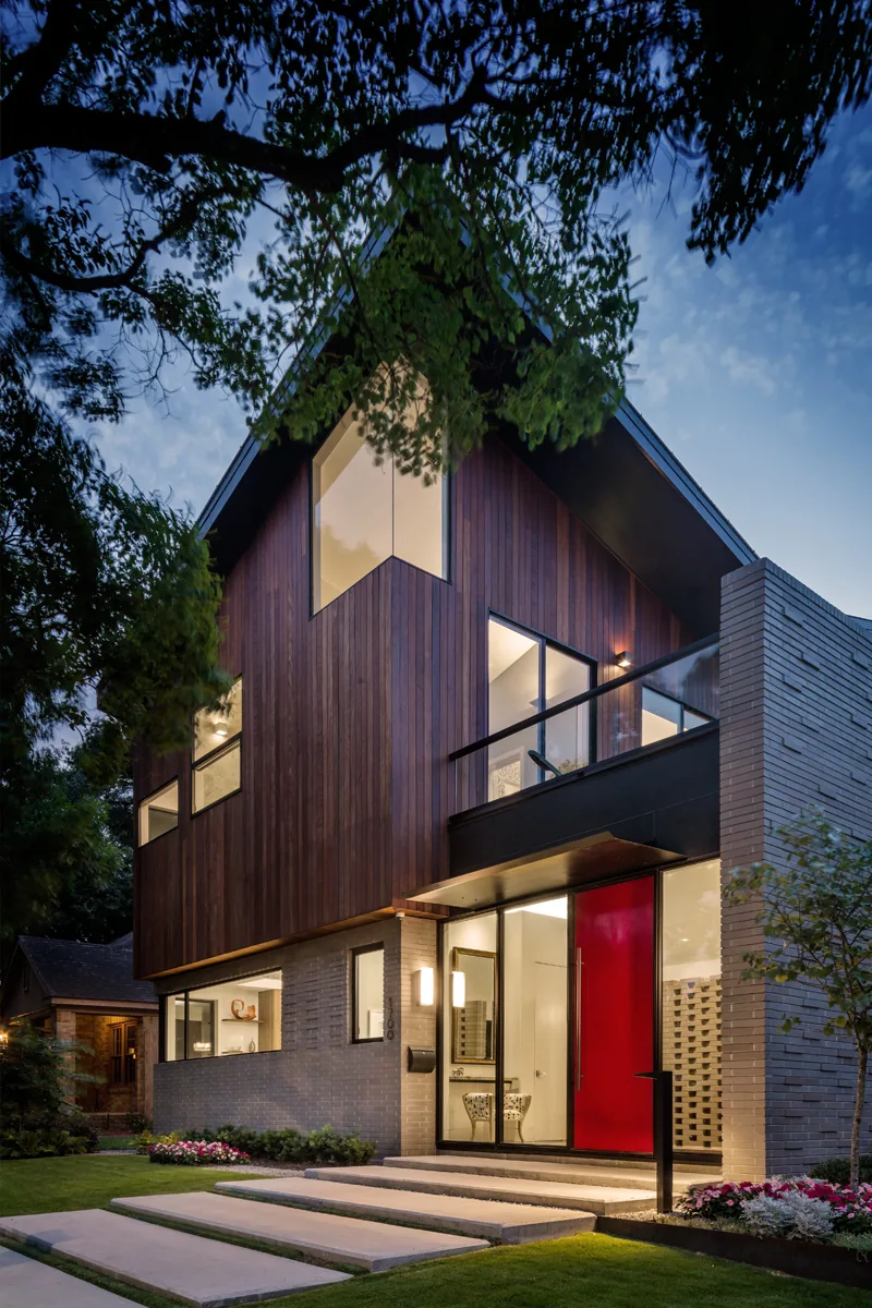 HOUSE 1700 in Houston features contemporary design with wood and brick siding and a red front door.