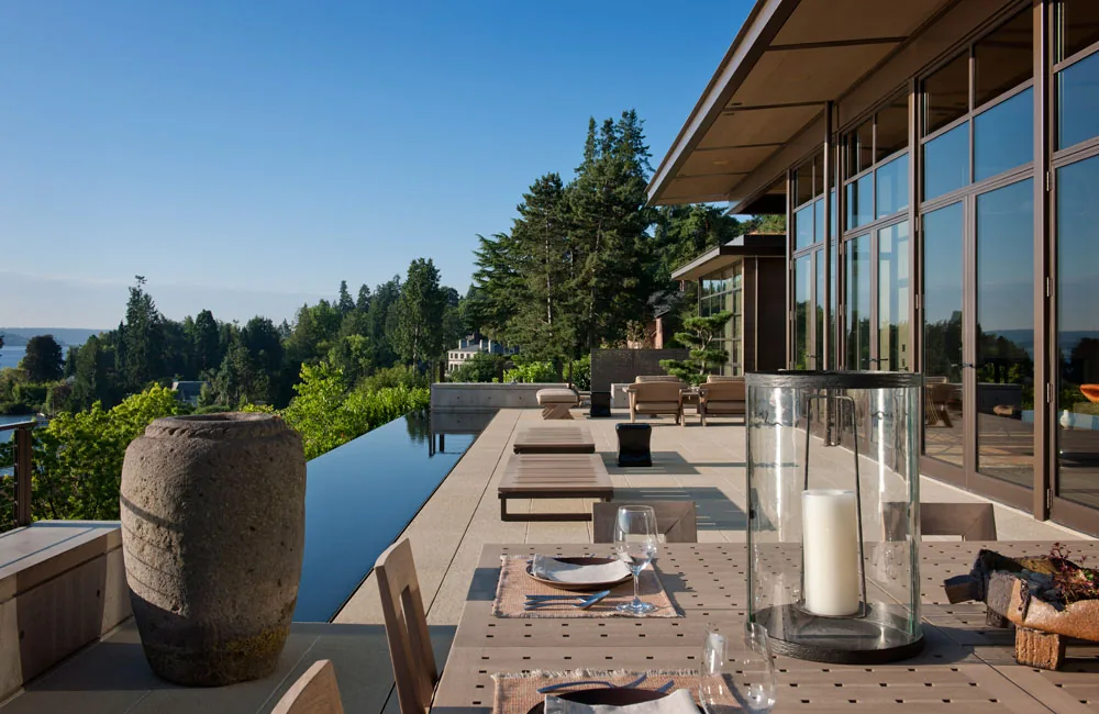 Washington Park Residence features a modern outdoor patio with an infinity pool and large glass doors opening to the interior living spaces.