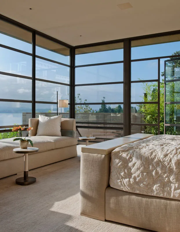 Bedroom with floor-to-ceiling black window frames offering expansive views.