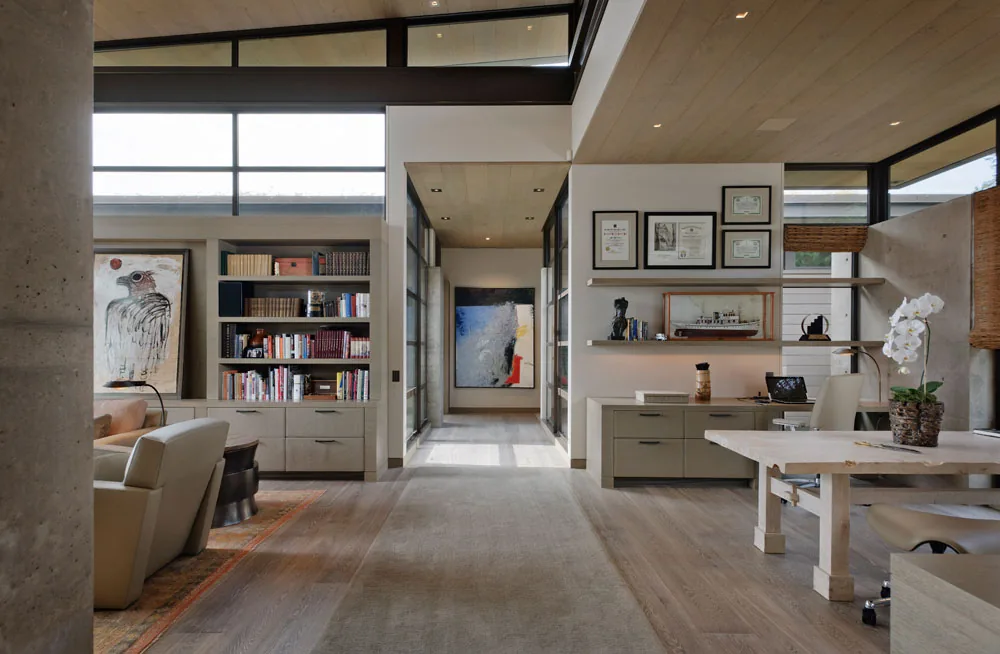 Washington Park Residence office space features wood-paneled ceiling, built-in bookshelves, and multi-pane windows by Conard Romano Architects.