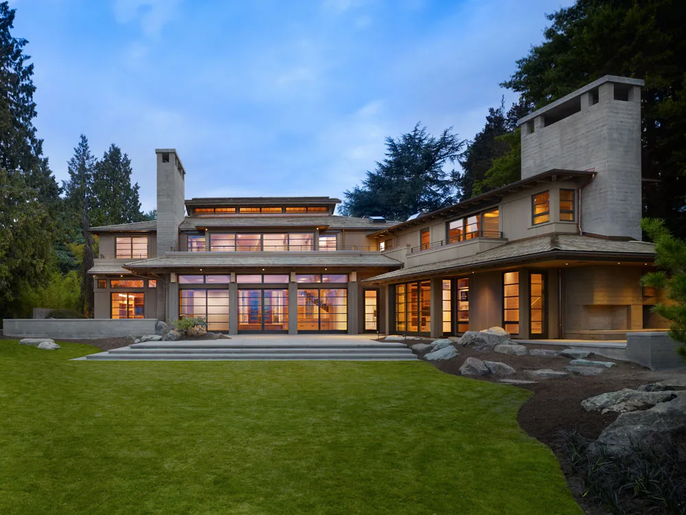 The Engawa House in Seattle features large wood grid windows and multiple concrete chimneys.