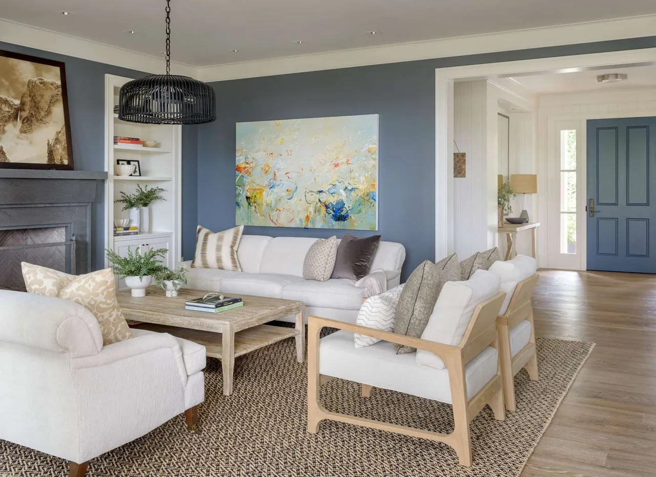 Living area in a modern farmhouse style with blue accent wall and light wood furniture.