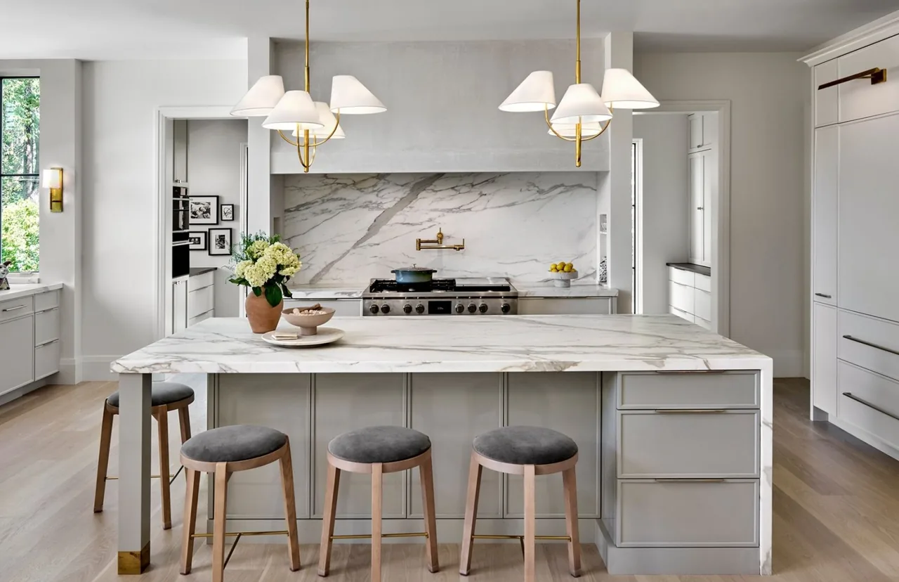 Naperville transitional residence kitchen with a large marble island and pendant lighting by Charles Vincent George Architects.