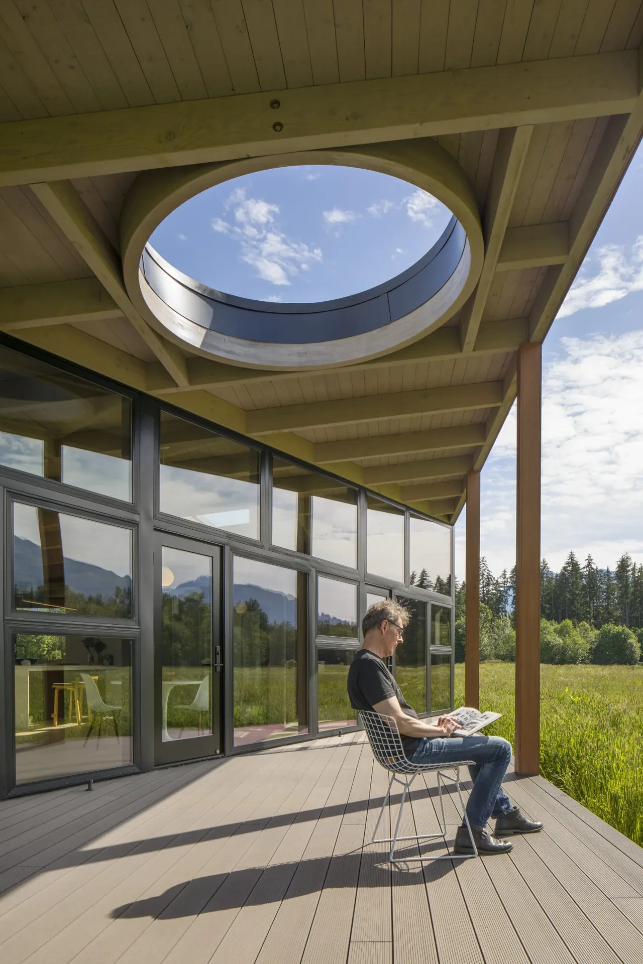 Field House patio features a sloped wood beam roof with circular skylight and black-framed windows.