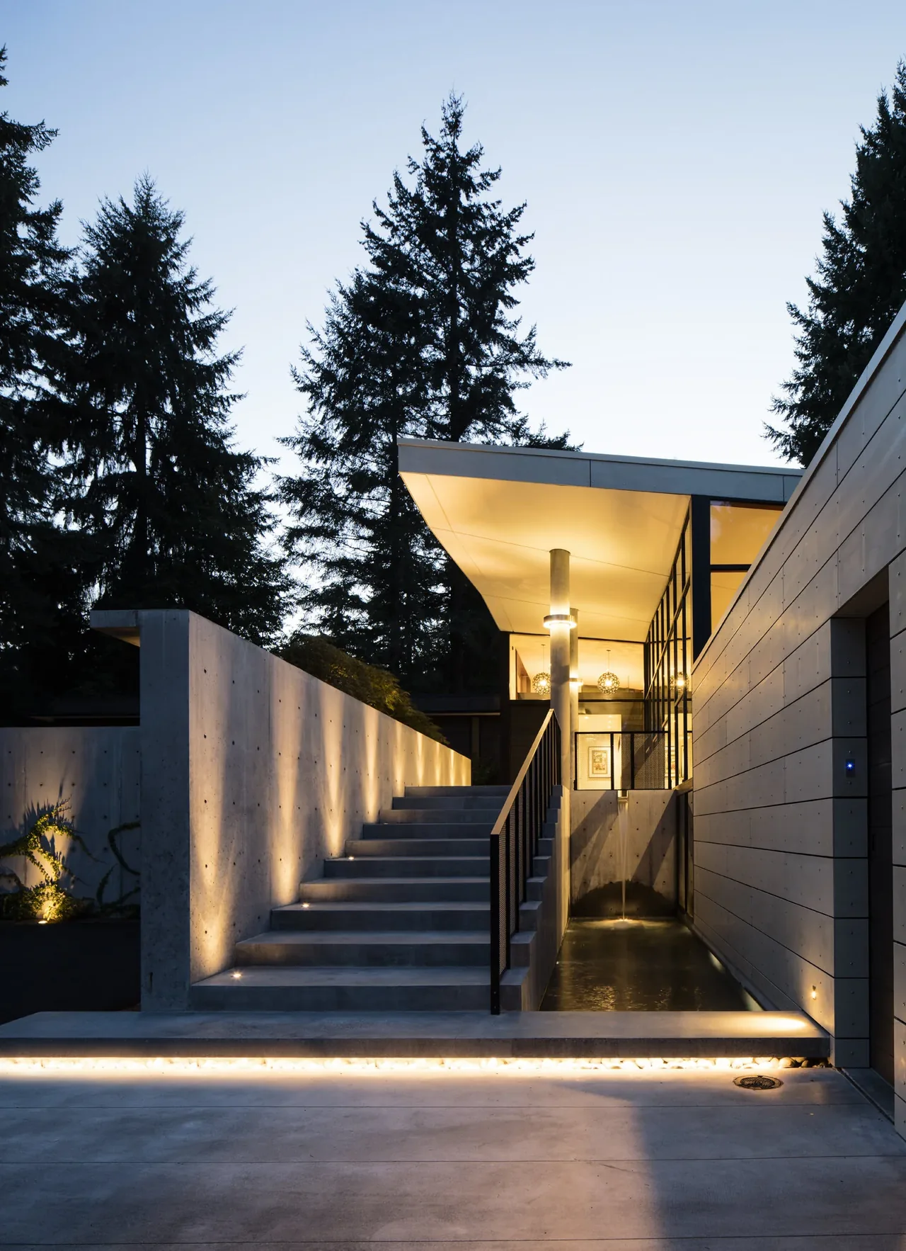 Concrete stairs with lighting lead to the entrance of the Inside Outside House by David Coleman Architecture in Seattle.