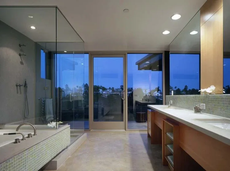 Bathroom features a glass shower enclosure, double vanity with wood cabinetry, and a glass door with views.