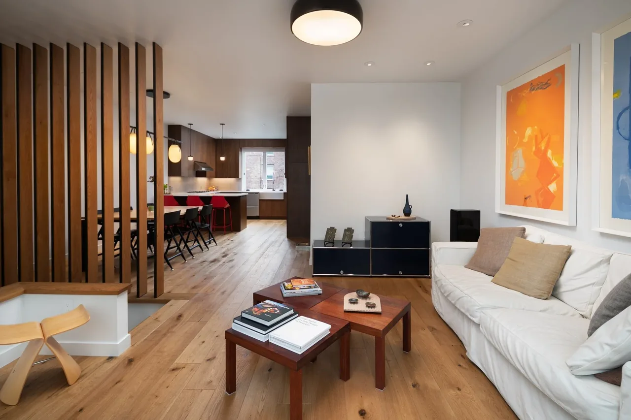 Open living and dining area with wood flooring and vertical slat divider in E Denny Way Townhouse Renovation.