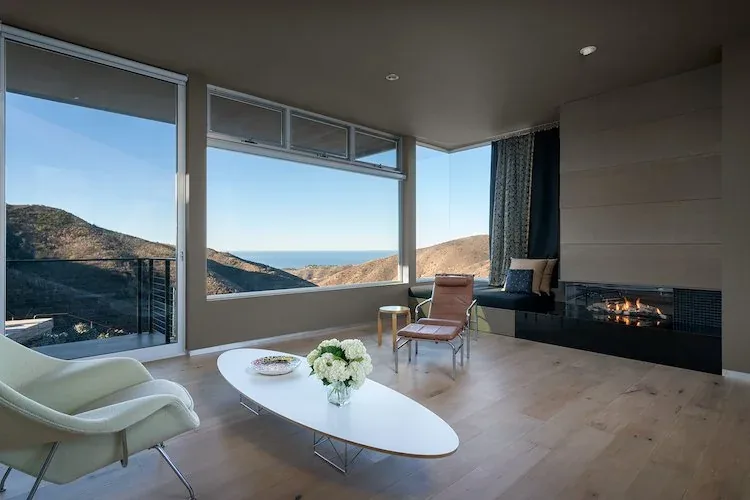 Yerba Buena Residence III living room with expansive windows and a contemporary fireplace designed by Cory Buckner Architects.