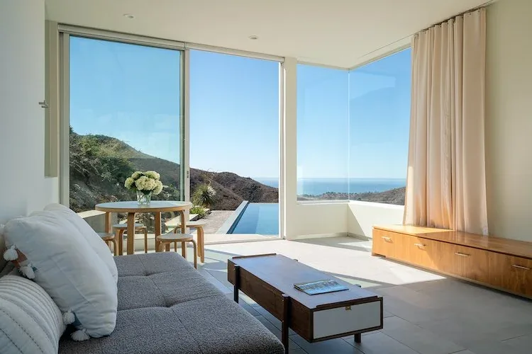Living room with large corner windows and a built-in bench at Yerba Buena Residence III