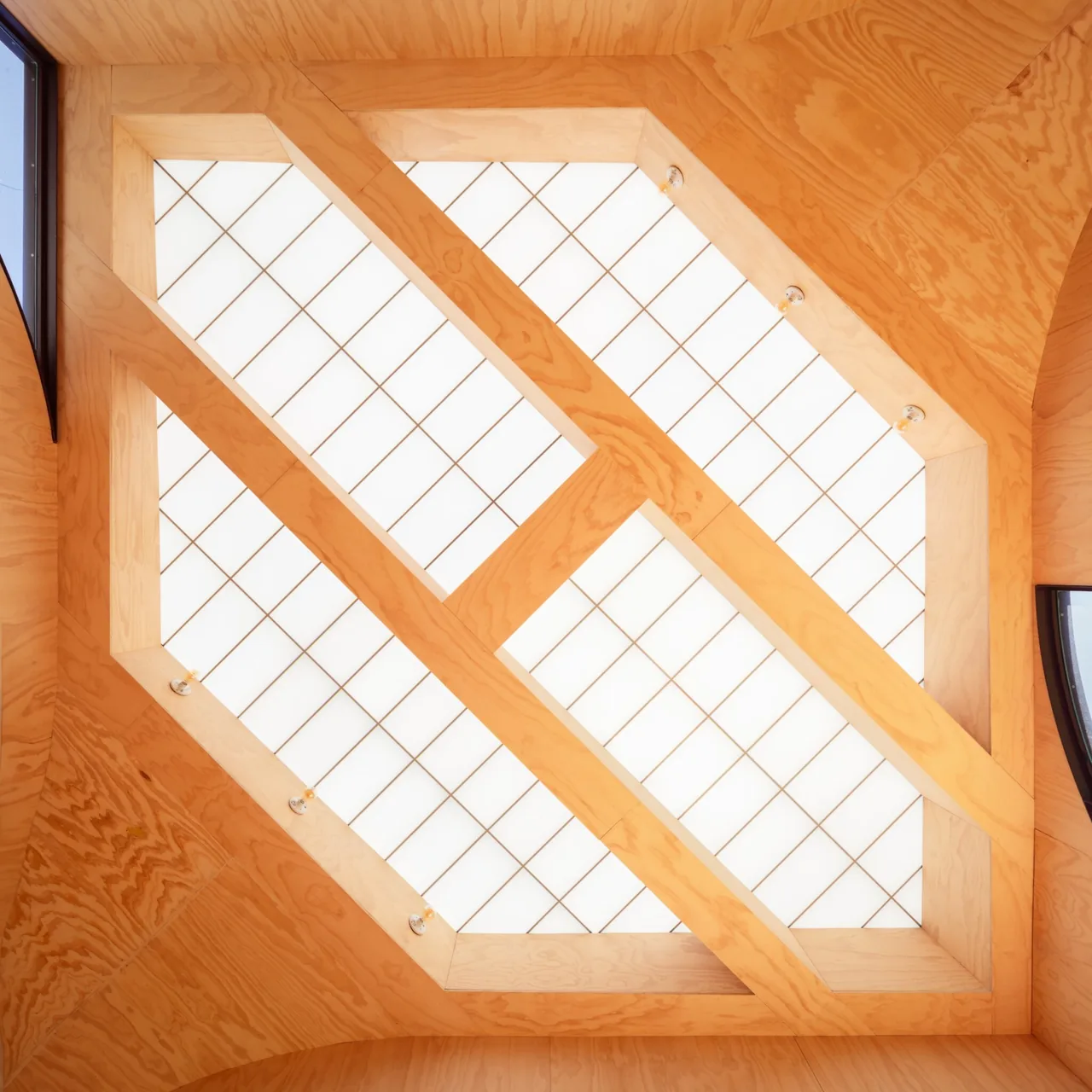 Interior ceiling featuring a geometric wood frame with translucent ceiling panels.