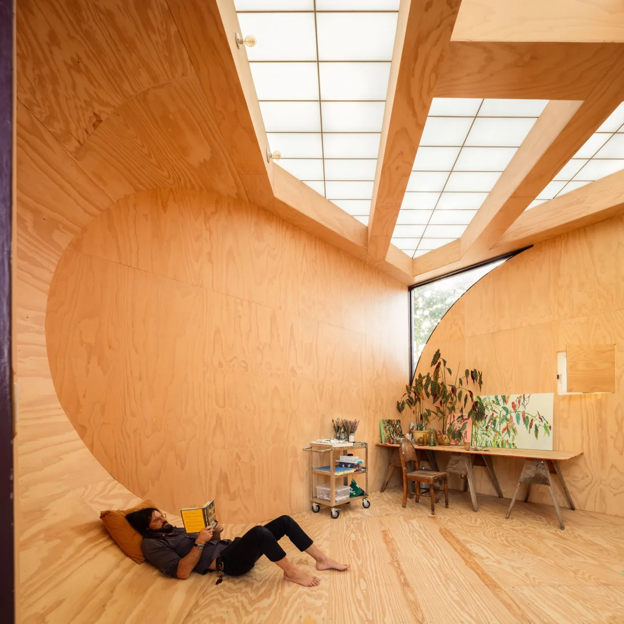Interior of The Sandtrap features continuous curved plywood walls and ceiling with a translucent panel roof providing diffused light.