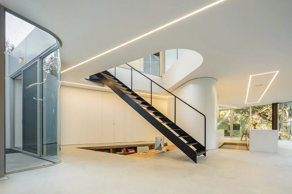Pam & Paul’s House features a black metal stair with glass railing and a sunken office, designed by Craig Steely Architecture.