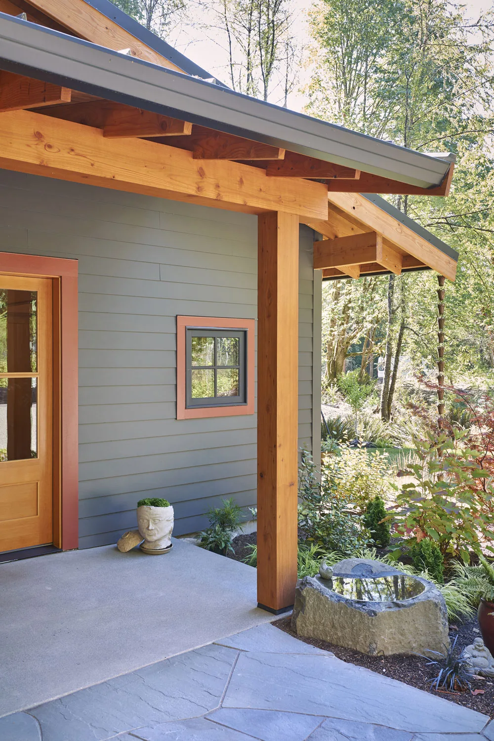 Front porch area of Bainbridge Island Farmhouse showing exposed wood beams and a small window with peach trim.