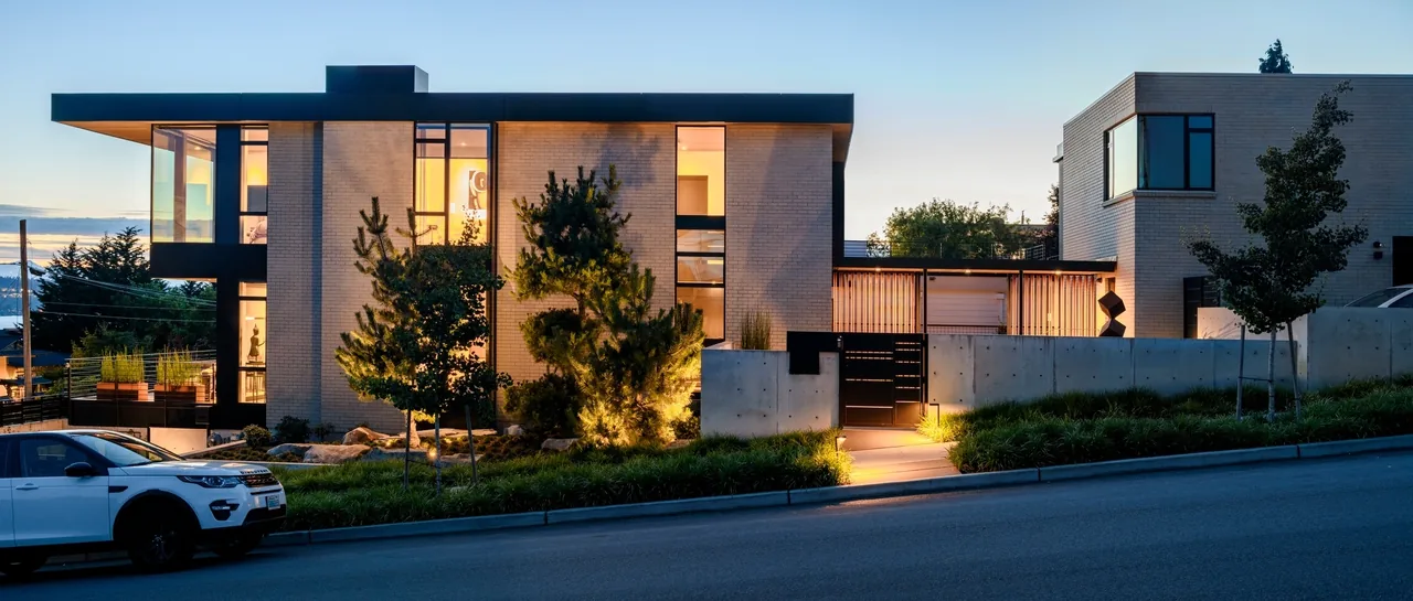 West of Market project features a modern home with concrete retaining walls and multi-level terraces on a sloped site.