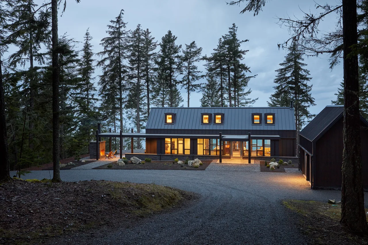 The Buck Mountain Residence features a modern barn-style exterior with standing seam metal roofing and large windows.