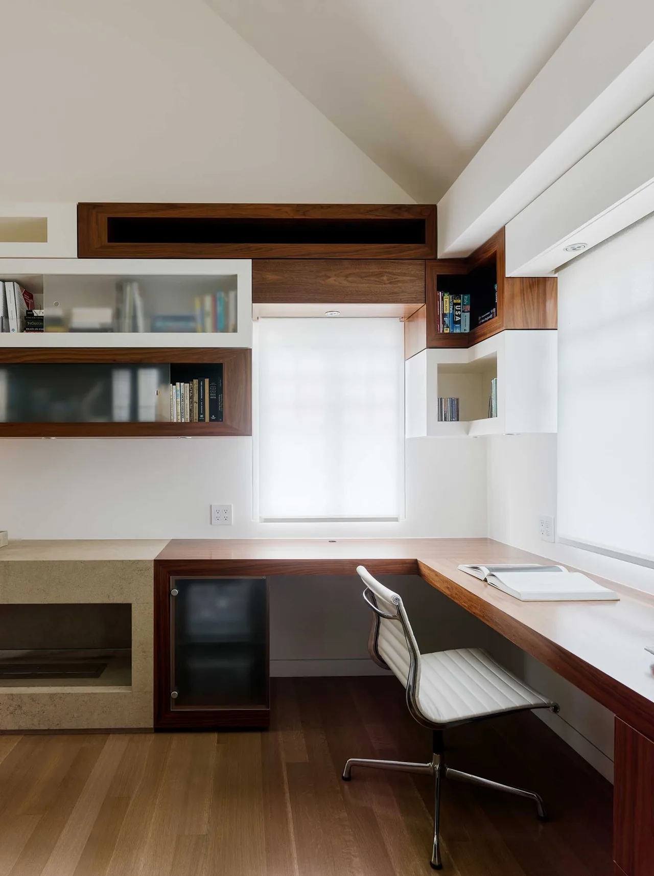 Minimalist home office in Claremont Residence with custom wooden desk and storage cabinetry by Debbas Architecture.