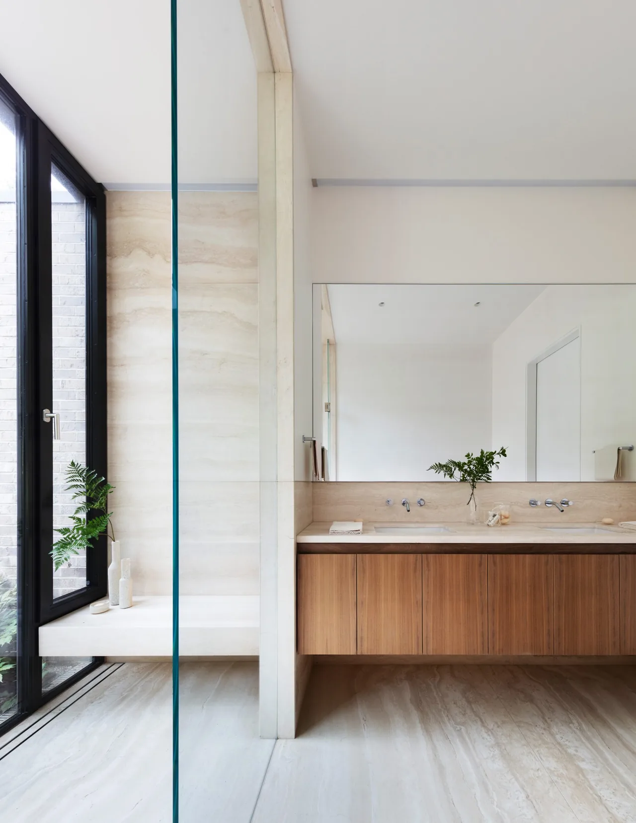 Bathroom in New Canaan Pavilion with wooden vanity, marble countertop, and large mirror by Deborah Berke & Partners.