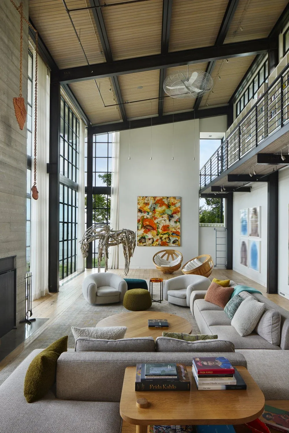 The Bluff living room features floor-to-ceiling glazing and exposed steel beams in a modern design by DeForest Architects.
