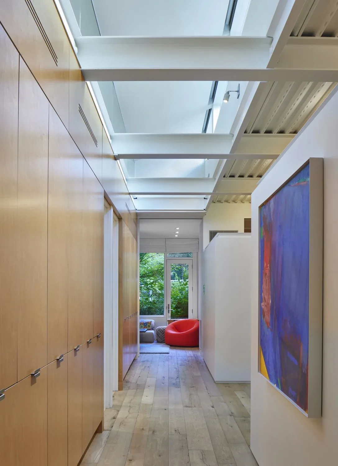 The Bluff features a long narrow interior passage with continuous wood cabinetry and skylights above.