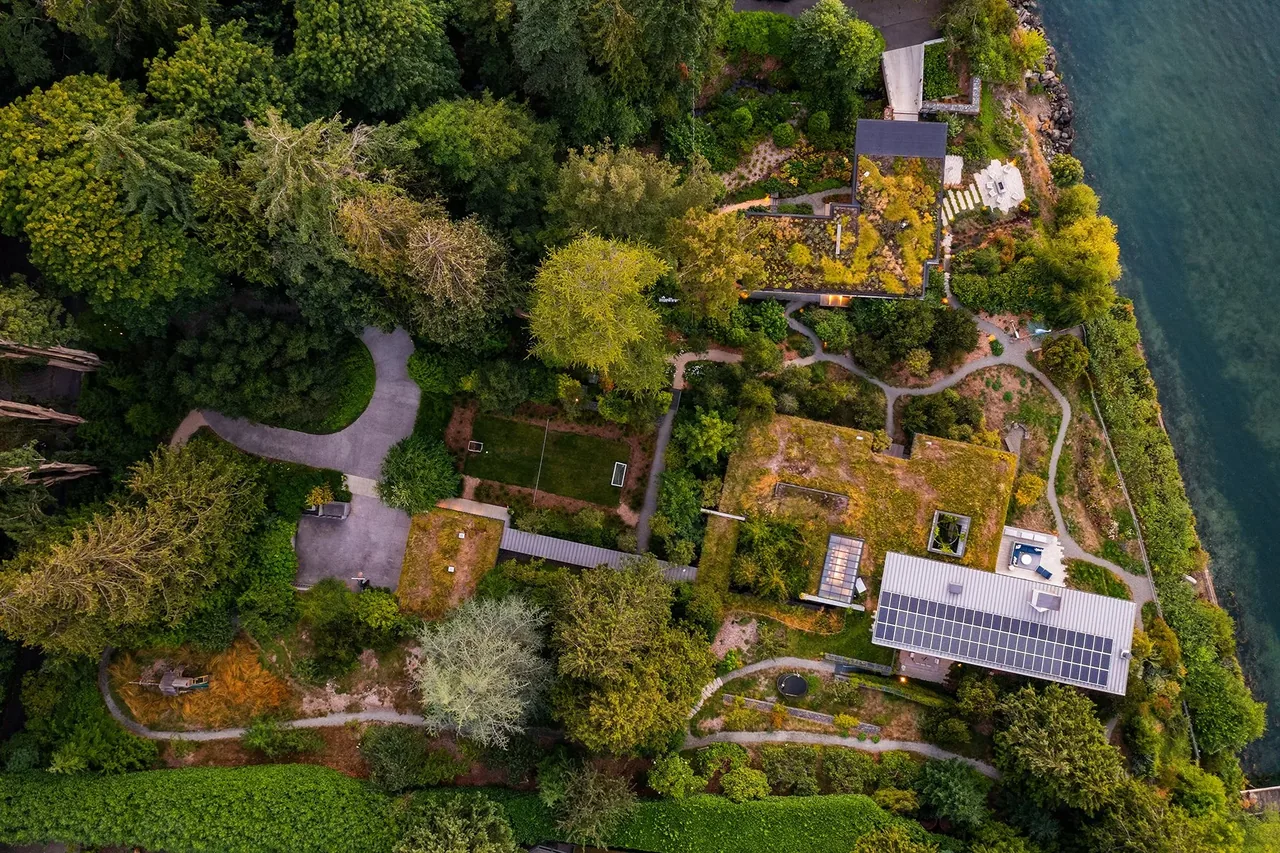 The Bluff features green roofs and solar panels on a waterfront property with paths weaving through dense vegetation.