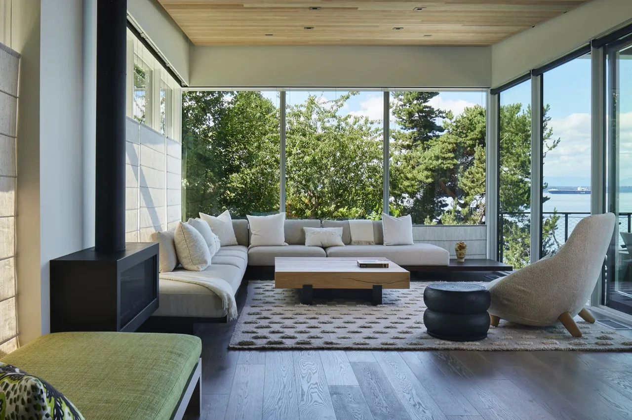 The Creek House living room with floor-to-ceiling glazing offers expansive views of nature and water.