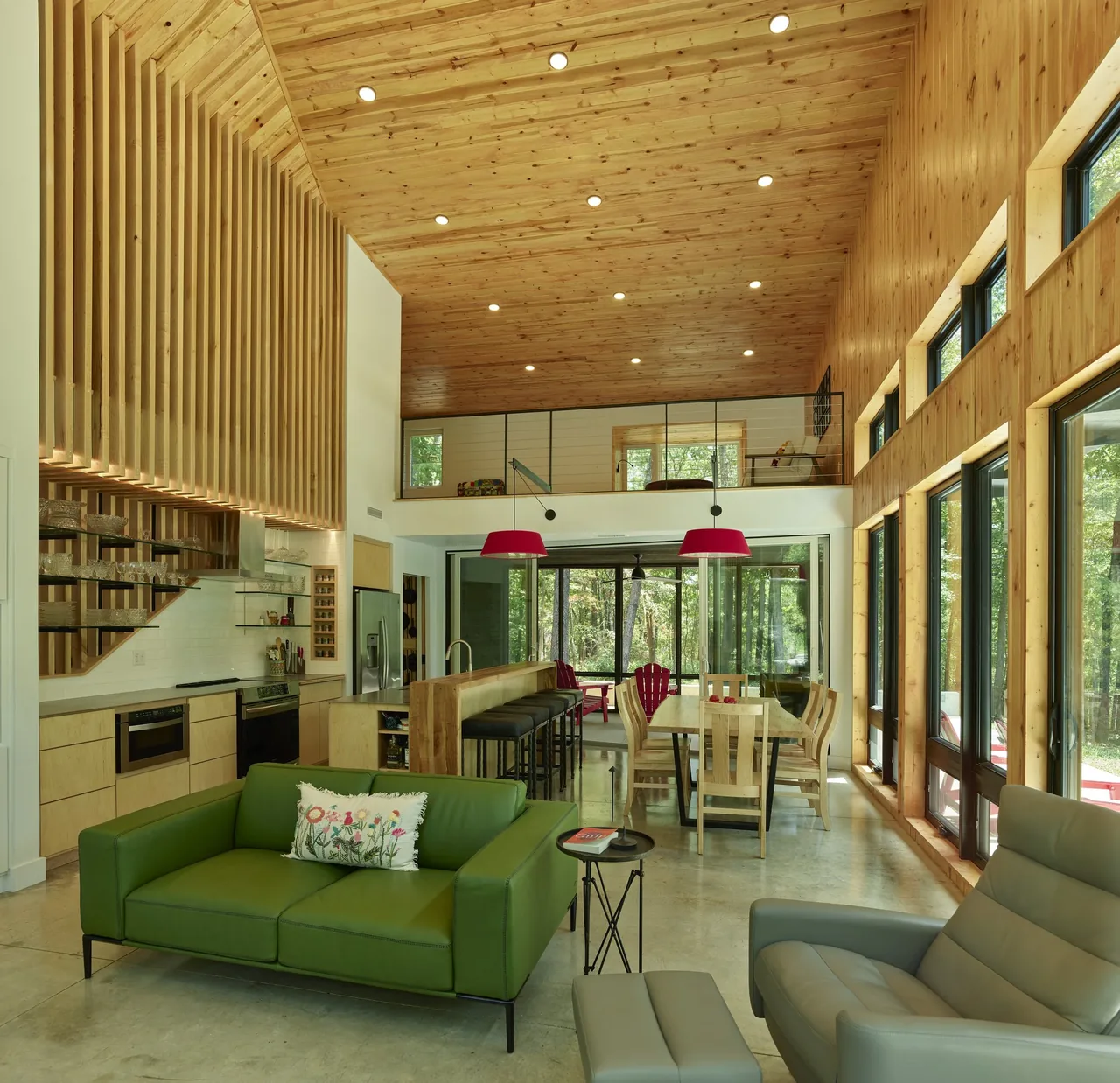 Eclipse Ridge living space features wood-paneled vaulted ceiling and extensive black-framed windows overlooking the outdoors.