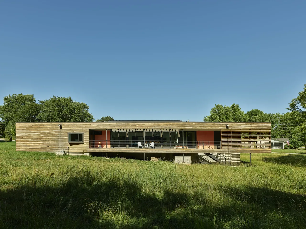 The Willis Residence by deMx Architecture features wood siding, a cable-railing deck, and a concrete base.