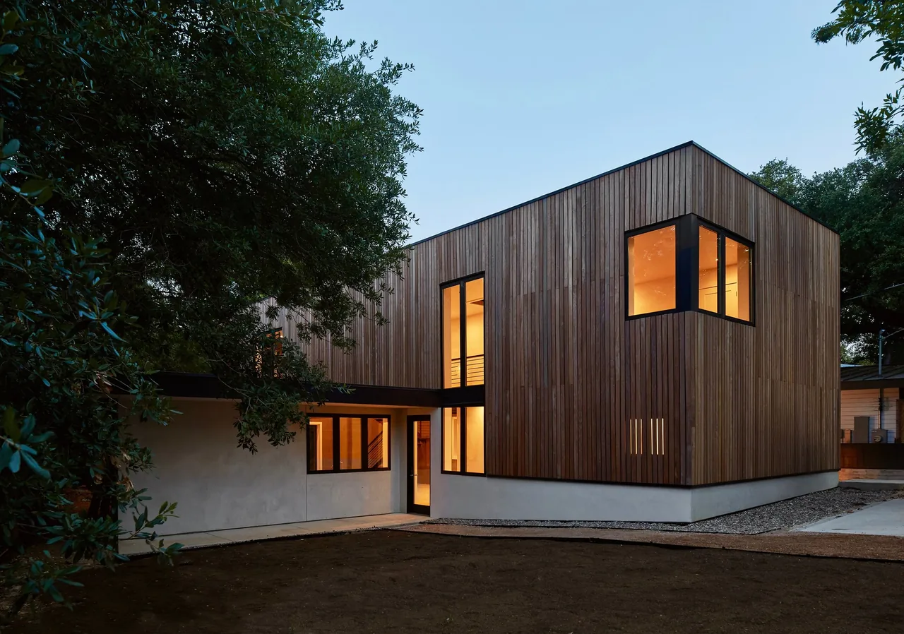 Jesse Street House by Derrington Building Studio in Austin features a two-story design with vertical wood siding and black window frames.