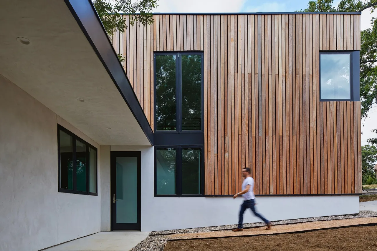 The Jesse Street House by Derrington Building Studio features vertical wood siding and black-framed windows.
