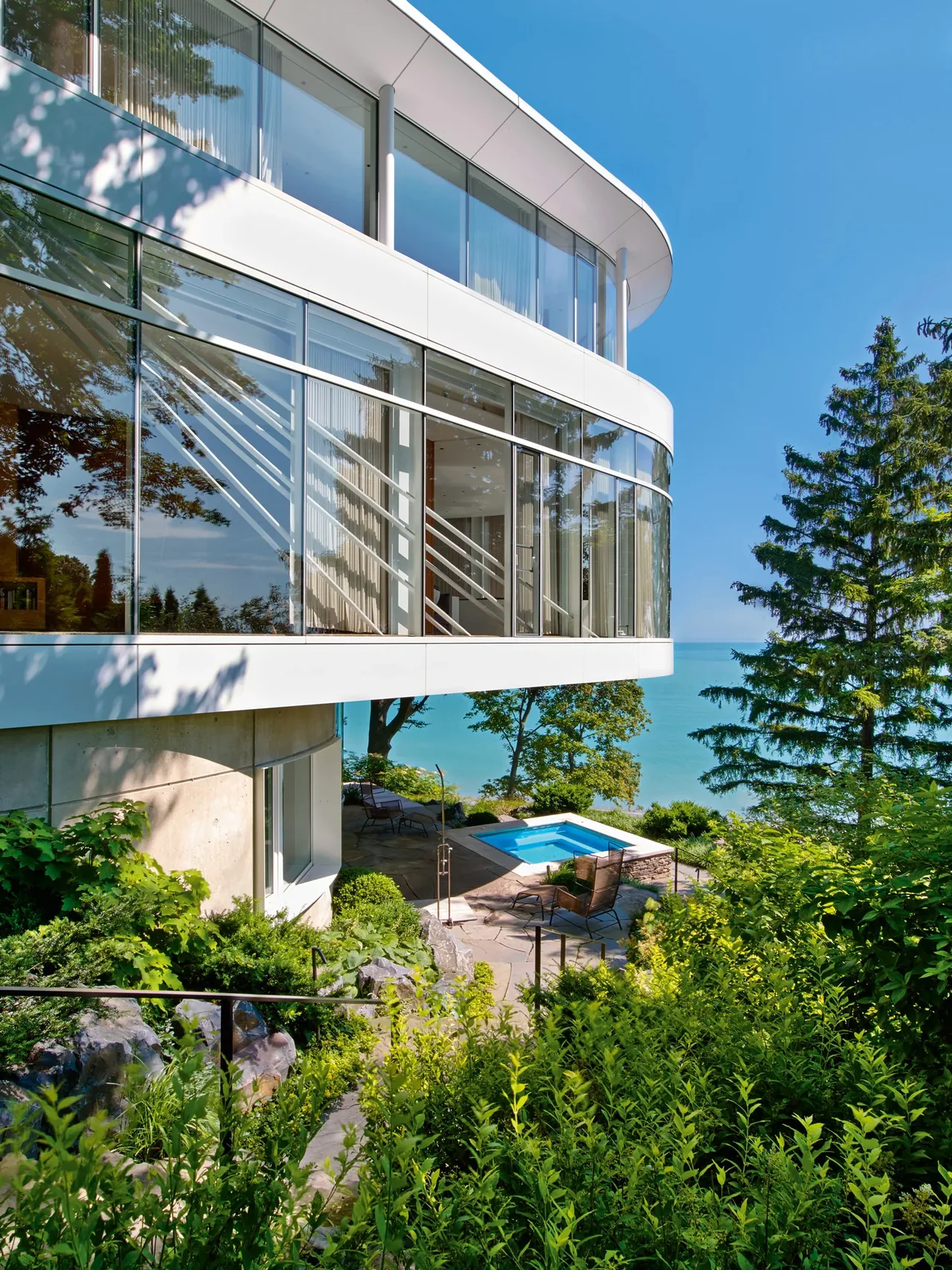 The Lake Michigan Residence features a curved upper floor with extensive glass walls overlooking Lake Michigan.