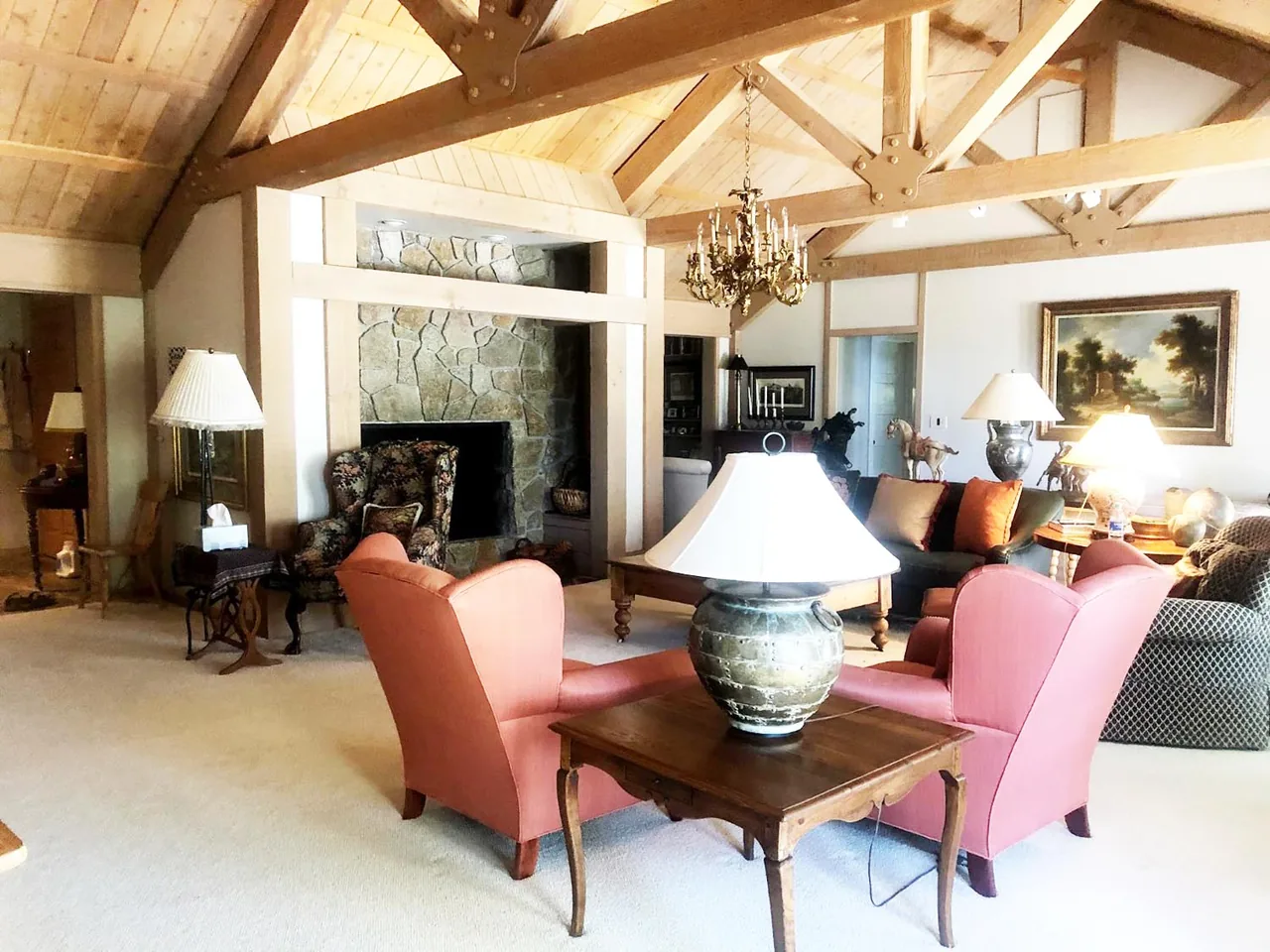 The Bold Tahoe Lodge living room features exposed timber trusses with a stone fireplace and traditional furnishings.