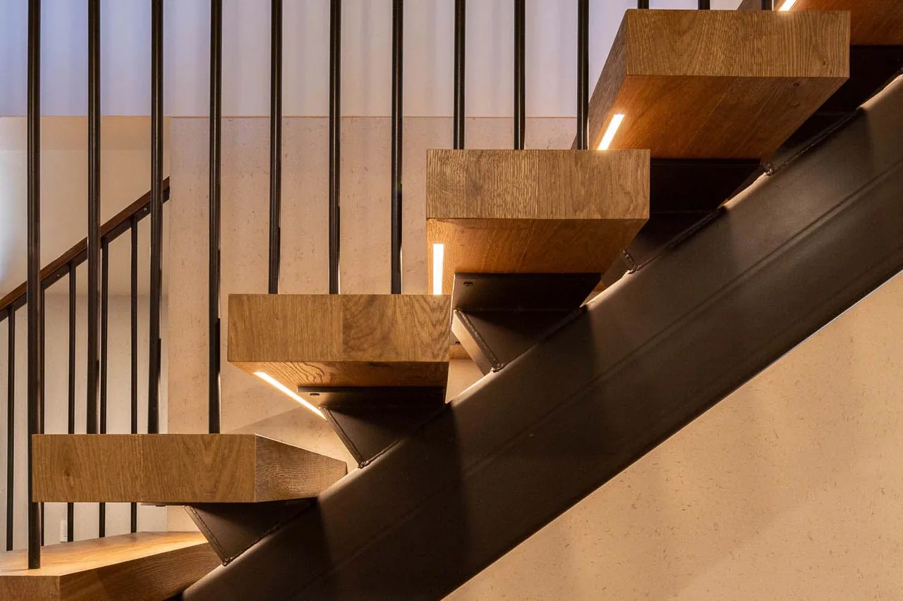 Modern floating staircase featuring thick wooden treads and vertical black metal railing supports.