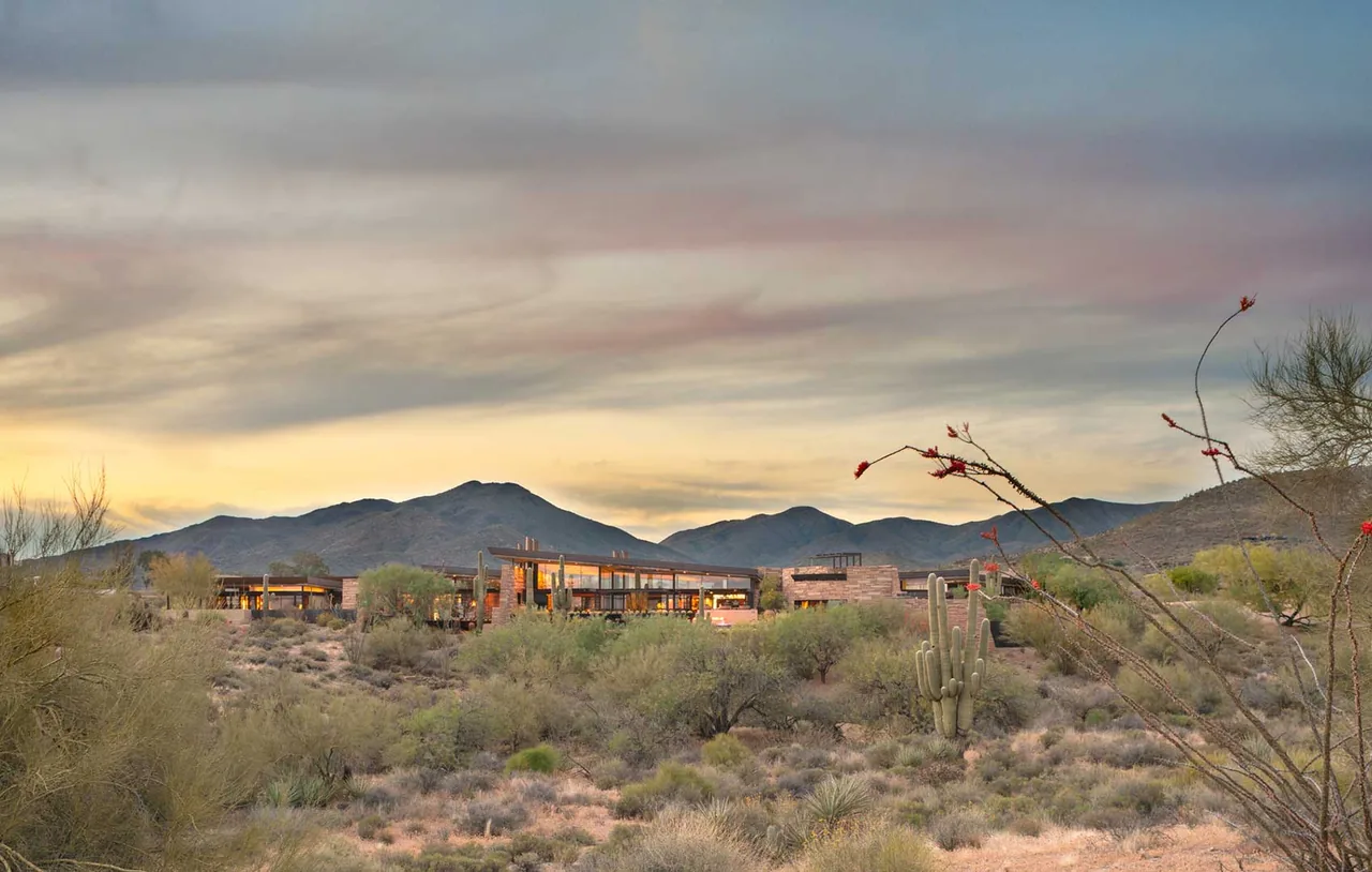 Saguaro Ridge by Douglas Fredrikson Architects is a low, modern home blending wood siding and floor-to-ceiling glazing with the desert environment.