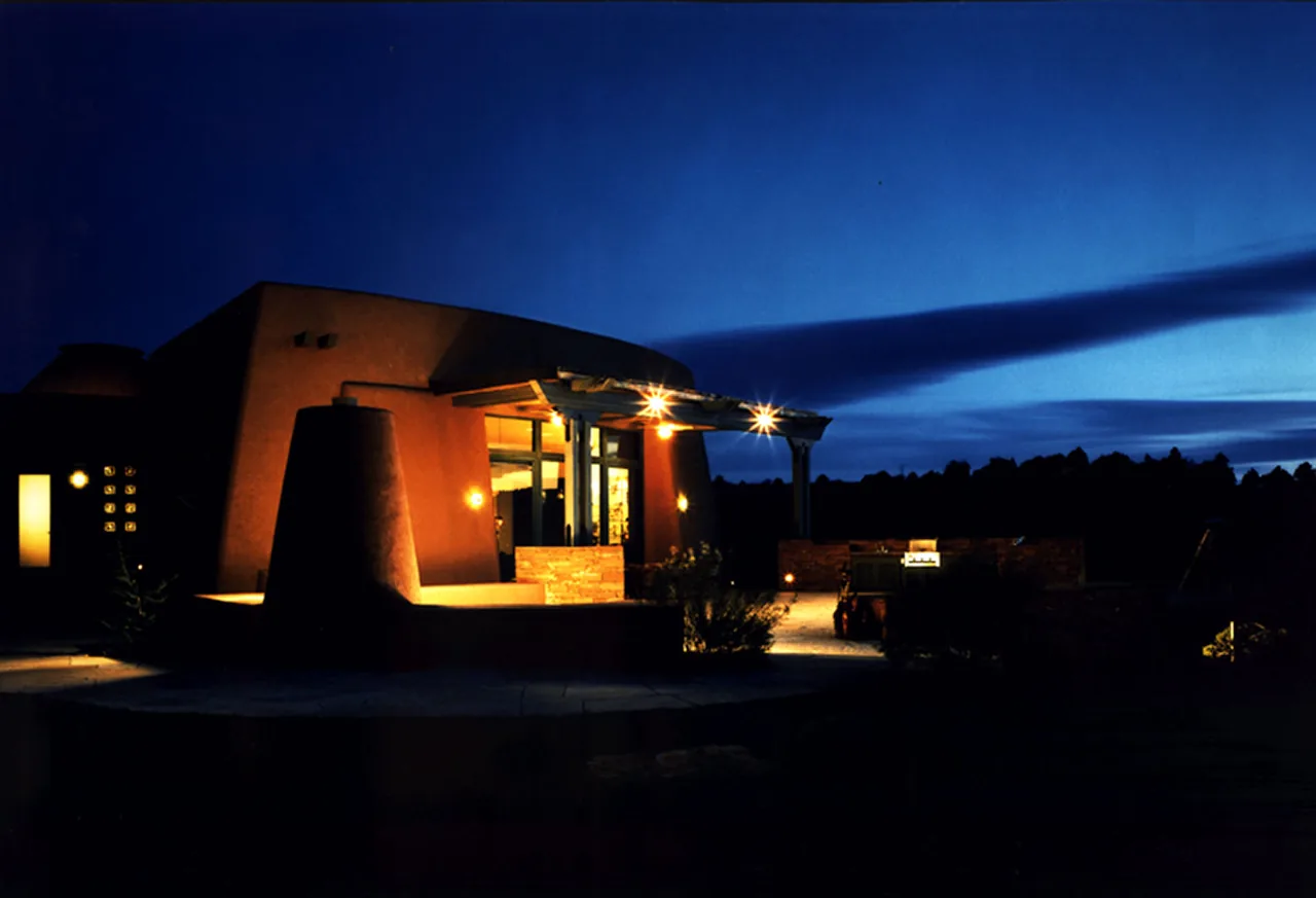 El Rojo Grande residence shows adobe walls with outdoor lighting at twilight in Phoenix.