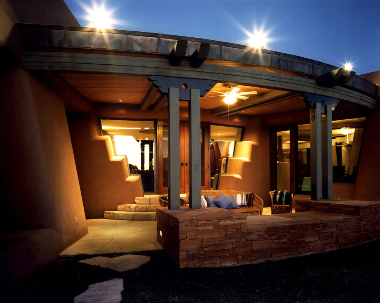El Rojo Grande features an outdoor covered patio with adobe-style walls and stone seating walls by Douglas Fredrikson Architects.