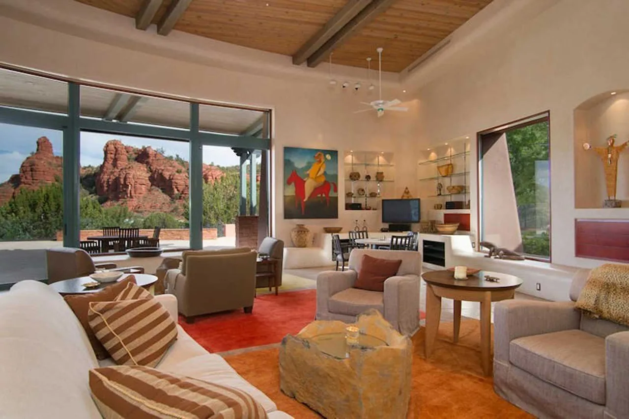 El Rojo Grande living room by Douglas Fredrikson Architects features floor-to-ceiling glazing with desert rock views and exposed wood beam ceiling.