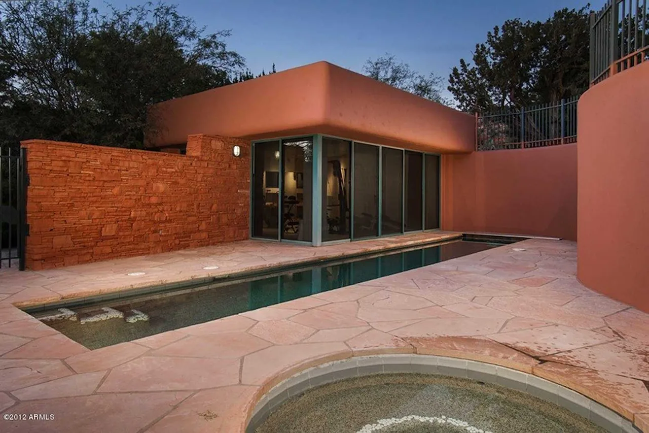 El Rojo Grande features a narrow pool set against adobe and stone walls with scenic desert landscaping.